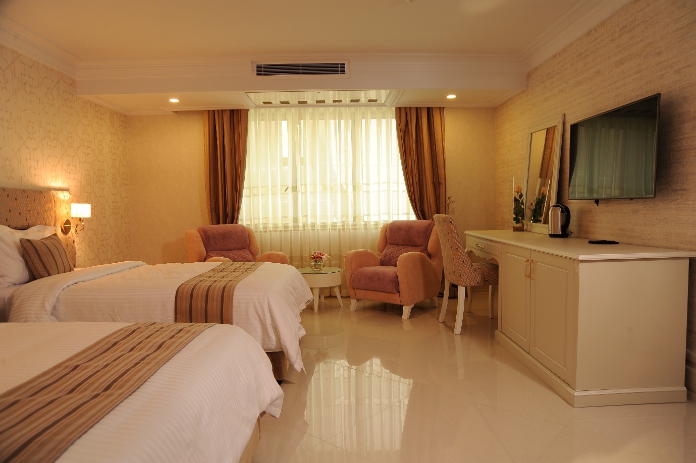 A room with two beds and a tableAI-generated content may be incorrect.